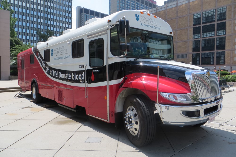 The bloodmobile parked outside a building.
