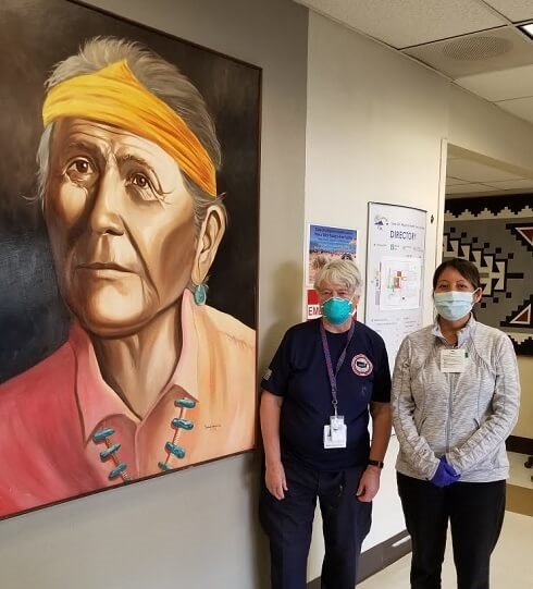 Susan Briggs, MD, stands with one of the hospital’s ED nurses next to an unidentified portrait