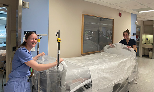 Two staff members pushing a new inpatient bed