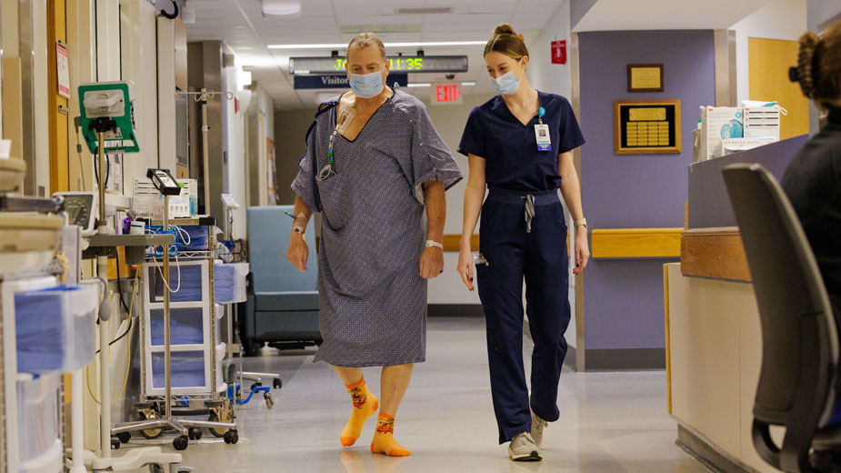 Tim walking the halls of Blake 6 after his transplant with Melanie Brodner, RN, BSN.