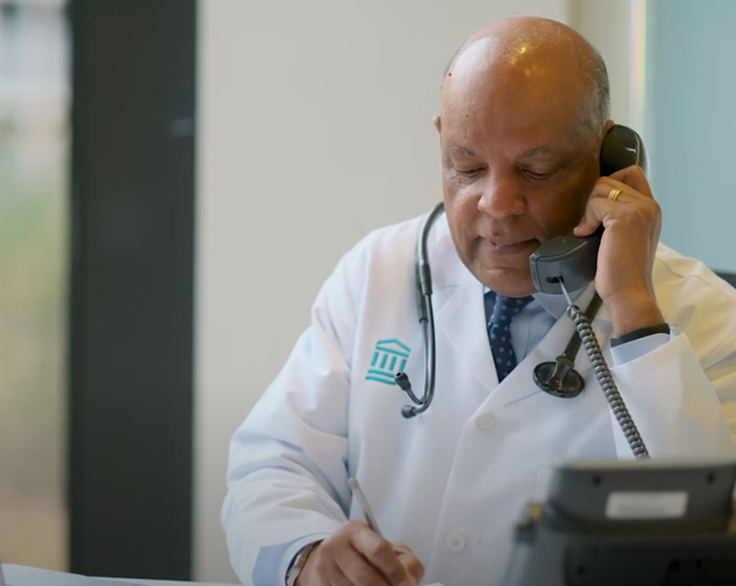 A male provider at desk on telephone