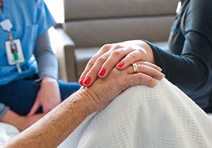 A patient and provider holding hands