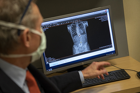 Dr. Braun examines an X-ray of Meg Armstrong's spine.