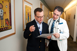 Photograph of Self-advocate resource specialist Ben Majewski consulting with Jose Florez, MD, PhD, in the adult clinic