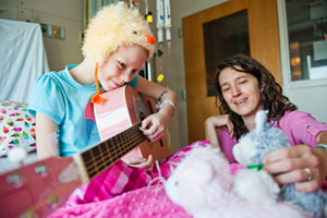 Image of girl playing guitar with   music therapist