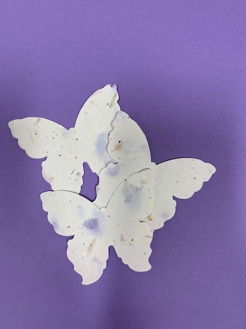 Three paper butterflies on a purple background.