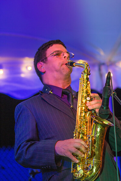 An adult Williams Syndrome patient plays the saxophone at an event