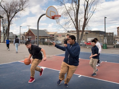 Kids playing basketball on a neighborhood playground