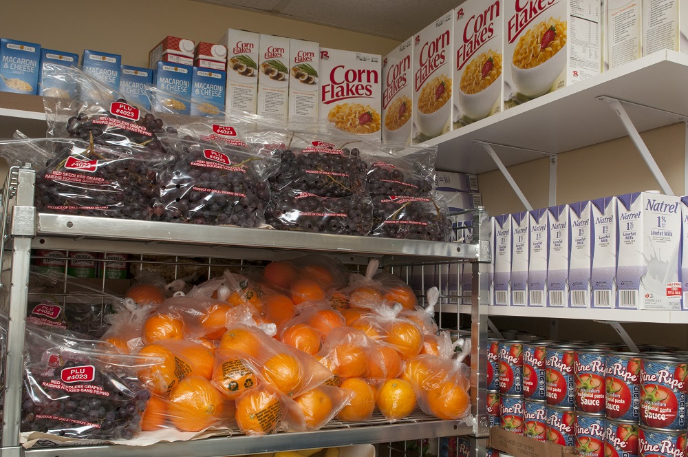 Shelves full of oranges, grapes, corn flakes and other food at the pantry