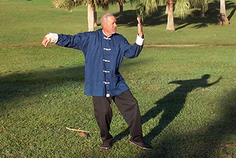 David Scraders practicando Tai Chi cerca de un río.