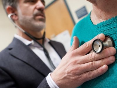 A doctor listens to a patient's heart using a stethoscope