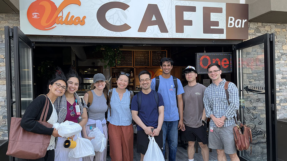 A group of people standing in front of a cafe