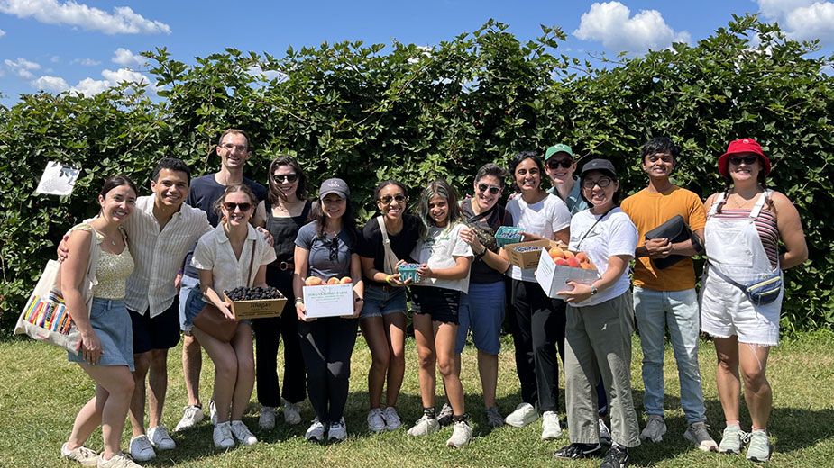 A group of people showing off the fruit they picked.
