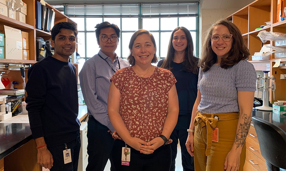 Five individuals standing in a lab