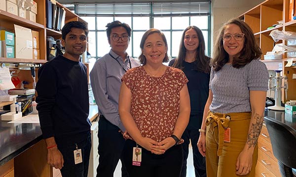Five individuals standing in a lab