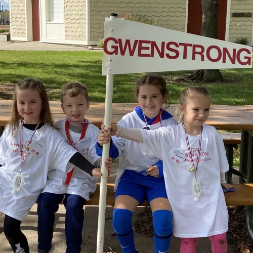 Children posing with GWEN STRONG banner