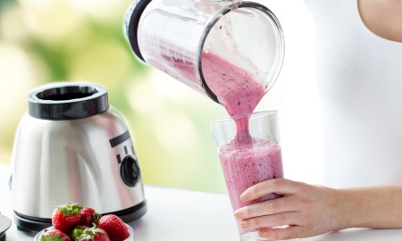 Woman pouring smoothies into a glass