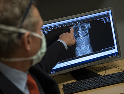 Dr. John Braun reading a spinal x-ray on a computer