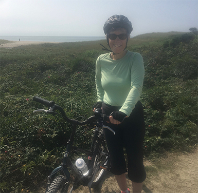 Janet, a patient of Dr. Daniel Tobert who is an Orthopaedic Spine Surgeon, biking on Nantucket