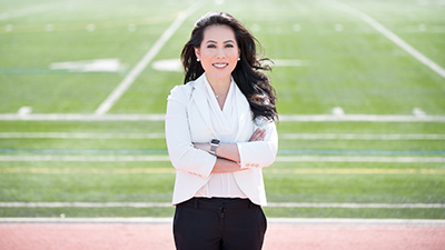 Miho Tanaka, MD, PhD next to a football field