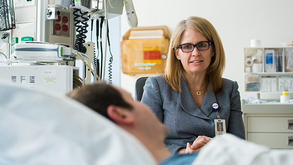 Felicia Smith, MD, speaks with a patient in the hospital.