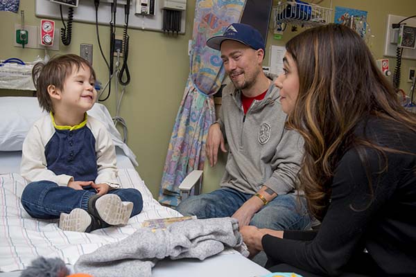 Pediatric patient with smiling family at bedside.