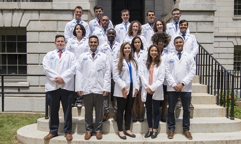 Surgery residents stand outside in their white coats