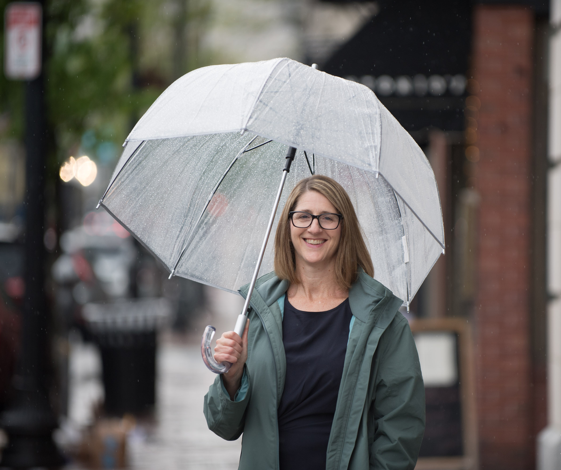 Holding an umbrellas, a patient smiles for the camera.