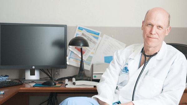 Christopher Morse, MD smiles while sitting at his desk
