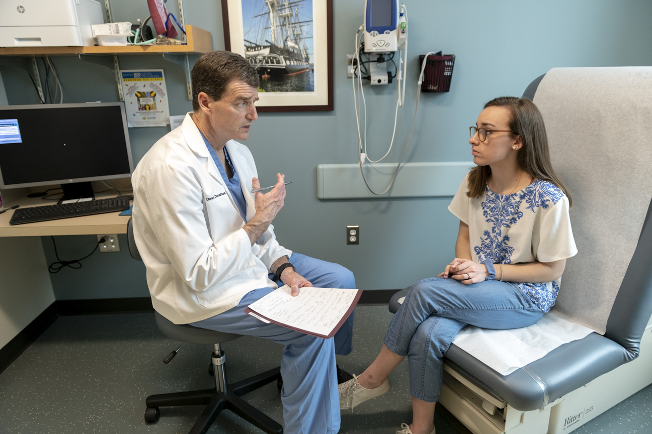  provider speaking with a pediatric thoracic outlet syndrome patient in an exam room.