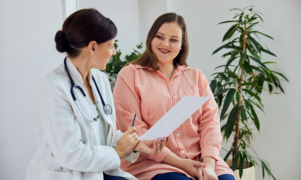 female clinician reviewing document with female patient in exam room