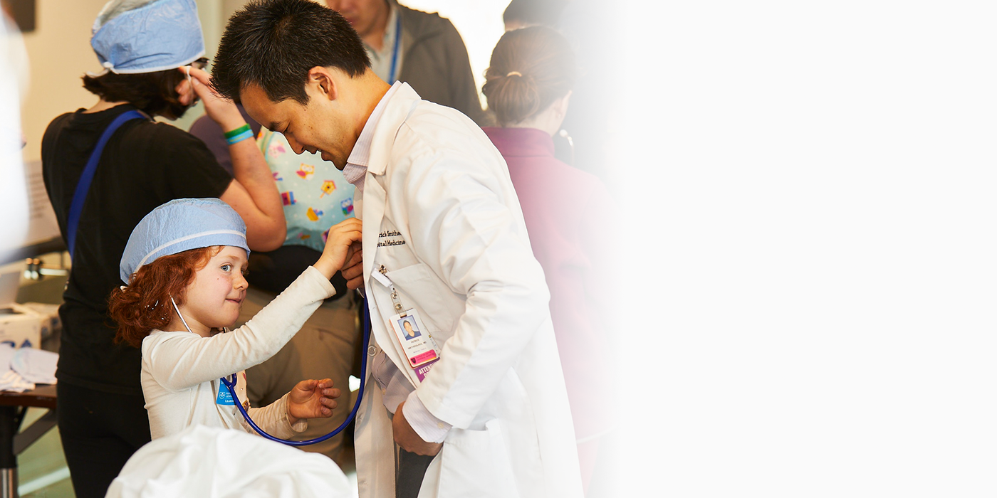 young pediatric patient using stethoscope on her doctor during an event
