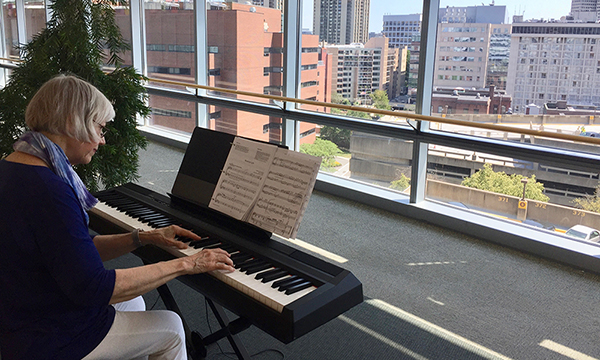 Person playing piano in the Yawkey building. Person playing piano in the Yawkey building.