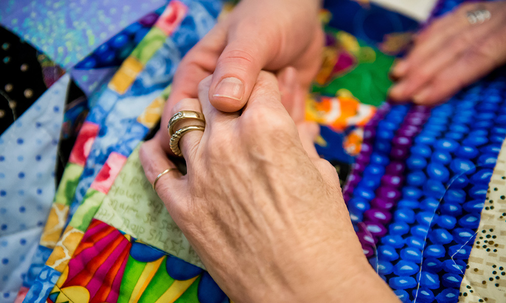 Holding hands on infusion quilt. Holding hands on infusion quilt.