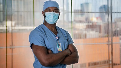 Worker with crossed arms and a mask