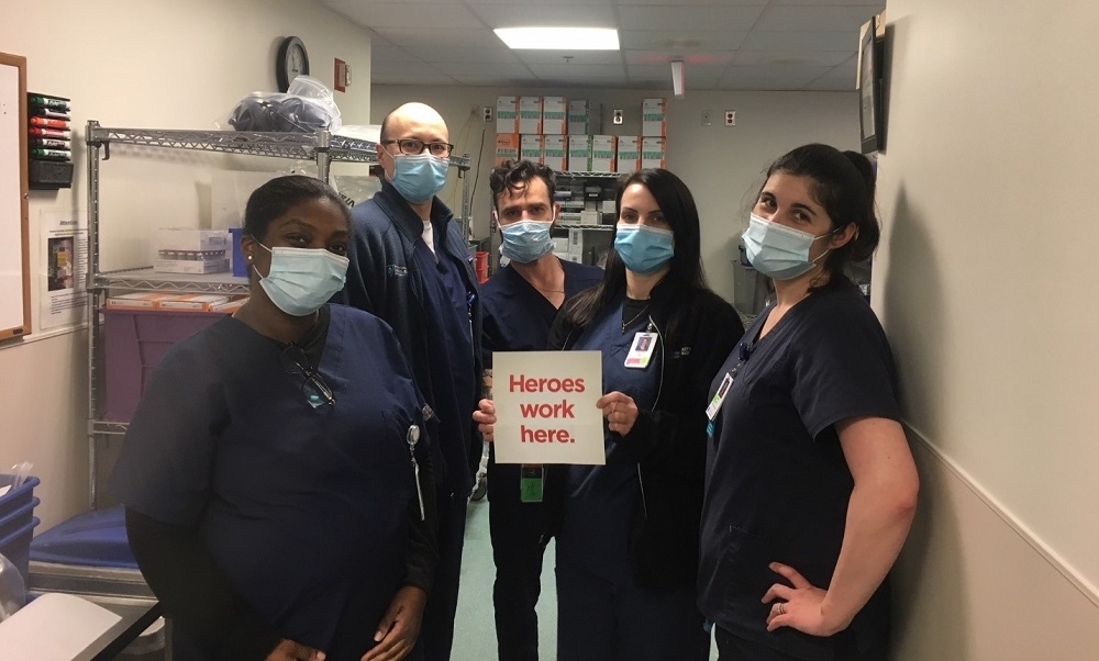 Staff members with masks pose for a photo Staff members with masks pose for a photo