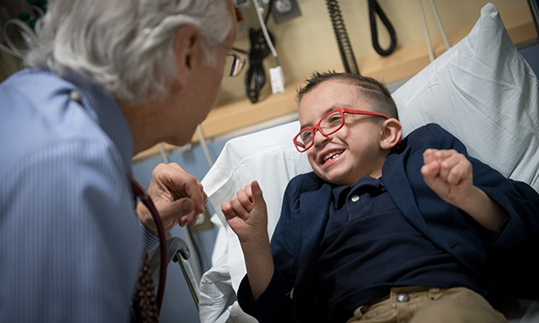 Pediatric Hematology-Oncology patient Cris smiles up at Howard Weinstein, MD, Chief, Pediatric Hematology-Oncology Pediatric Hematology-Oncology patient Cris smiles up at Howard Weinstein, MD, Chief, Pediatric Hematology-Oncology
