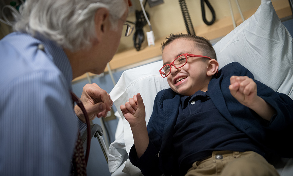 Pediatric Hematology-Oncology patient Cris smiles up at Howard Weinstein, MD, Chief, Pediatric Hematology-Oncology Pediatric Hematology-Oncology patient Cris smiles up at Howard Weinstein, MD, Chief, Pediatric Hematology-Oncology