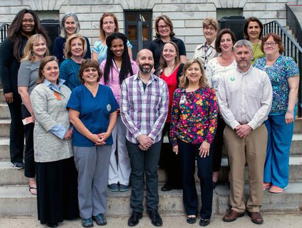 The members of the Family Advisory Council pose on the steps of a stone building