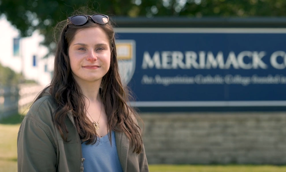 Mass General for Children patient, Maeghan, standing in front of Merrimack College sign Mass General for Children patient, Maeghan, standing in front of Merrimack College sign