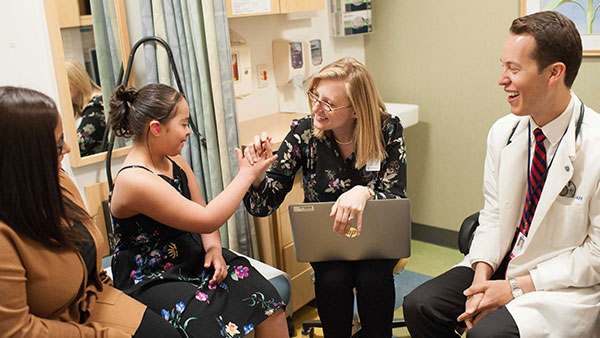 A team of providers talks with a patient and her family A team of providers talks with a patient and her family
