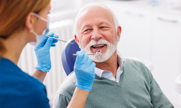 Female provider about to examine a patient's mouth Female provider about to examine a patient's mouth