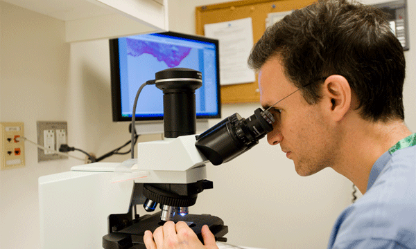 Mohs surgeon, Dr. Victor Neel looking into a microscope at a skin biopsy. Mohs surgeon, Dr. Victor Neel looking into a microscope at a skin biopsy.