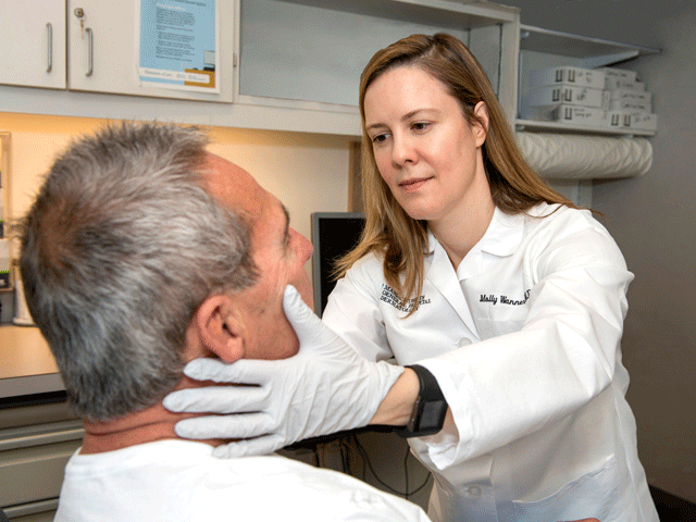 Cosmetic dermatologist, Molly Wanner, MD evaluating a man's skin.