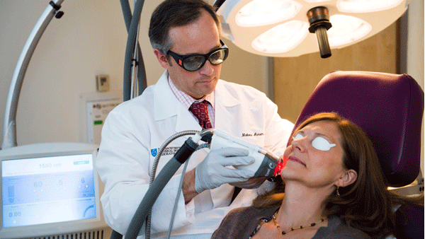 Dr. Avram using a laser to improve a woman's skin. Dr. Avram using a laser to improve a woman's skin.