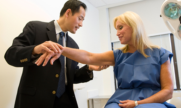 Dermatologist, Dr. Hensin Tsao examining a patient's skin. Dermatologist, Dr. Hensin Tsao examining a patient's skin.