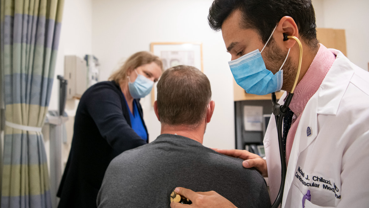A fellow and a faculty member tend to a patient A fellow and a faculty member tend to a patient