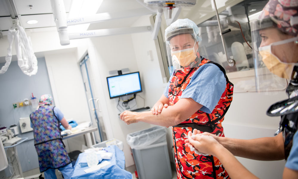 An ultrasounds technologist laughs with a patient on an exam table An ultrasounds technologist laughs with a patient on an exam table