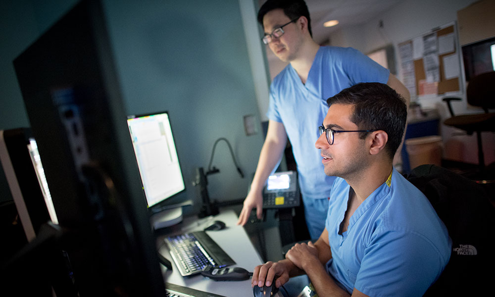 Radiologists view images on computer screens in a reading room Radiologists view images on computer screens in a reading room