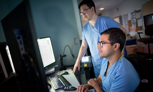 Radiologists view images on computer screens in a reading room Radiologists view images on computer screens in a reading room